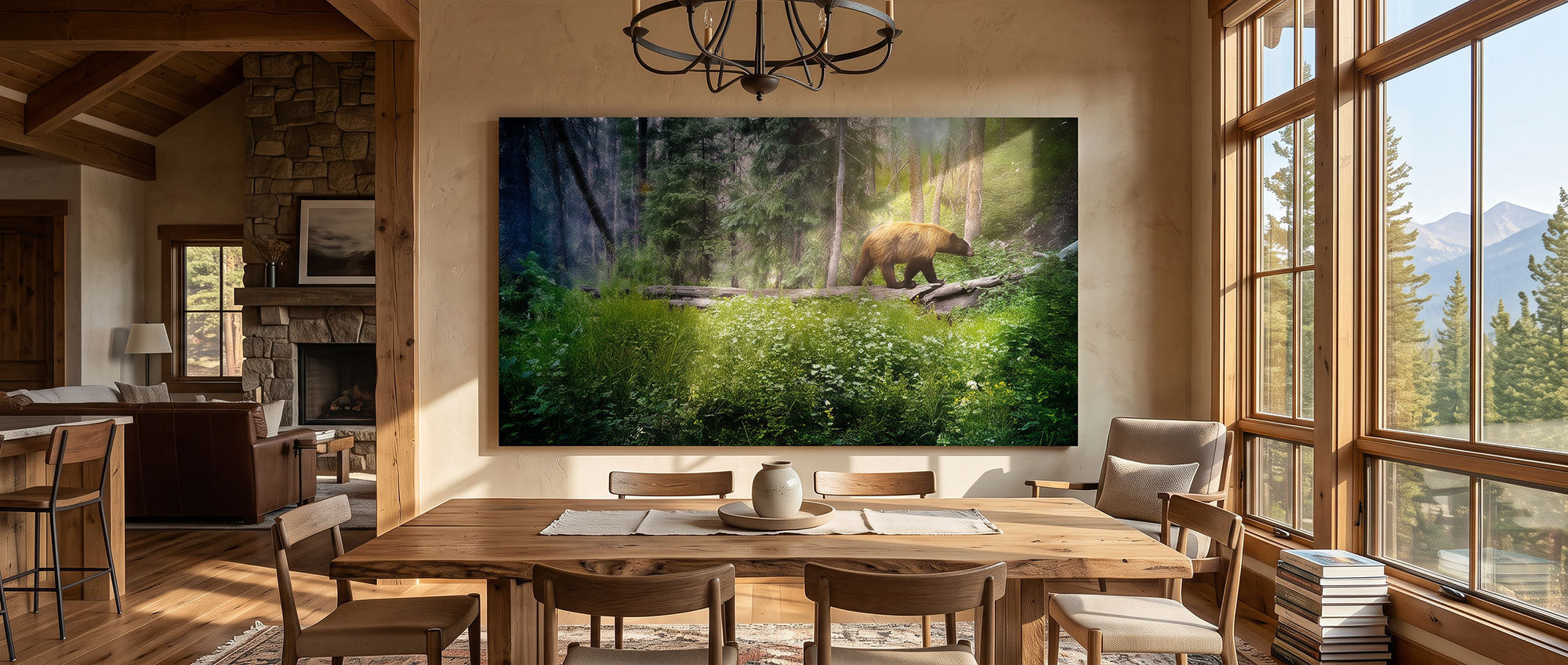 A large rectangular wall art print depicting a forest scene with a brown bear, displayed in a rustic dining room with a wooden table, chairs, stone fireplace, and tall windows.